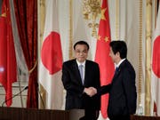 Handschlag als Symbol für das Tauwetter zwischen Peking und Tokio: Der japanische Premierminister Shinzo Abe (r) und sein chinesischer Amtskollege Li Keqiang (l) an einer gemeinsamen Medienkonferenz in Tokio. (Bild: Keystone/AP POOL Bloomberg/KIYOSHI OTA)