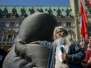 Der taiwanesische Künstler Kang Mu-Xiang letzte Woche mit einer 1,5 Tonnen schweren "Embryo"-Skulptur aus recycleten Liftkabeln - genannt "Unlimited Life" - in Hamburg. Weitere solche Skulpturen stehen derzeit auch am New Yorker Broadway. (Bild: Keystone/DPA/AXEL HEIMKEN)