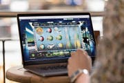 Ein Mann spielt auf einer Online-Casino-Seite auf seinem Computer am Zürcher Hauptbahnhof. (Bild: Gaëtan Bally/Keystone, 12. April 2018)