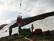 Ein Löschhelikopter flog Wasser vom Speichersee Nagens zum Brandort auf 2'650 Meter über Meer. (Bild: Kapo GR)