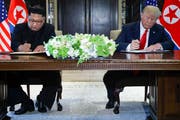 Kim Jong Un und Donald Trump beim Unterzeichnen des Abkommens zur nuklearen Abrüstung. (Bild: AP Photo/Evan Vucci)