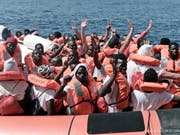 Flüchtlinge von der «Aquarius» winken, nachdem sie auf ein Boot der italienischen Küstenwache gebracht wurden. (Bild: Keystone/AP SOS Mediterranee/KENNY KARPOV)