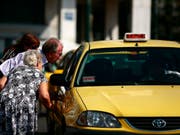 Ein älteres Paar sucht in Athen nach einem leeren Taxi. In der griechischen Hauptstadt und in Thessaloniki sind die Taxifahrer am Mittwoch in einen 24-stündigen Streik getreten. (Bild: Keystone/EPA/ALKIS KONSTANTINIDIS)