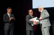 Von links: Unter den Augen von Laudator Yves Serra nimmt Prix-Caritas-Preisträger Sovannarith Sam die Glückwünsche von Caritas-Direktor Hugo Fasel entgegen. (Bild: Priska Ketterer (Luzern, 15. Juni 2018))
