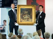 Mitarbeitende der Galerie Kornfeld präsentierten am Freitag dem Auktionspublikum das Gemälde «Die Gotthardpost» von Rudolf Koller. Einen Abnehmer fand das Bild aber nicht. (Bild: KEYSTONE/PETER KLAUNZER)