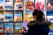 Eine Kundin studiert die Kataloge des Reisebüros Meile AG. Bild: Michel Canonica