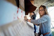 Führt eine alte Familientradition weiter: Trix Limacher bringt Holzschindeln an einer Fassade an. (Bild: Corinne Glanzmann (Alpnach, 14. Juni 2018))