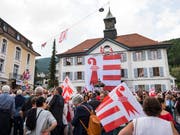 Mit einer Acht-mal-Acht-Meter grossen Fahne am Rathaus in Moutier wollen die Teilnehmer einer Veranstaltung die Zugehörigkeit zum Kanton Jura untermauern. (Bild: KEYSTONE/JEAN-CHRISTOPHE BOTT)