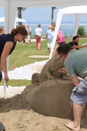 Der 1. Familien-Sandskulpturen-Wettbewerb hat nebst den Teilnehmenden auch viele Zuschauer zum Horner Festplatz gelockt. Im Bild die Arbeiten an der Chamäleon-Skulptur, die später siegte. (Bild: Martin Rechsteiner)
