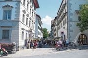 Blick in die St.-Oswalds-Gasse (grosses Bild), musikalische Unterhaltung (rechts oben) und ein gefragter Büchermarkt (rechts unten). (Bild: Bilder: Maria Schmid (Zug,16. Juni 2018))