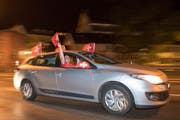 Jubelnde Fans mit Schweizerfähnchen am Sonntagabend am Blumenbergplatz. (Bild: Urs Bucher)
