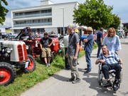 Heimbewohner und auswärtige Besucher begutachten die aufgereihten alten Traktoren. (Bild: Christoph Heer)