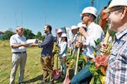 Der Roggwiler Gemeindepräsident Gallus Hasler übergibt die Baubewilligung an Projektplaner Sandro Nater. (Bild: Donato Caspari)