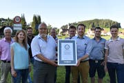 Das OK des Adventskranzes Mosnang (von links): Pius Hollenstein, Simona Zweifel, Lukas Länzlinger, Mario Breitenmoser, Max Gmür, Damian Oberhänsli und Ruben Schuler. Die GWR-Zeugen Edi Schnellmann und Ivan Louis halten die Urkunde. (Bild: Timon Kobelt)