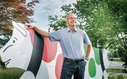 Peter Rüegg, Direktor der Sortenorganisation Tilsiter Switzerland GmbH in Weinfelden, mit der roten und der grünen Tilsiter-Kuh. (Bild: Andrea Stalder)