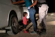 Ein Kind aus Honduras weint, während seine Mutter nahe der Grenze zu Mexiko durchsucht wird. (Bild: John Moore/Getty (McAllen, 12. Juni 2018))