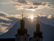 Kurz nach 6.32 Uhr am Donnerstagmorgen schien die Sonne zur Sommersonnenwende durch den Einschnitt zwischen den zwei Bergkuppen des Stanserhorns auf die Pfarrkirche von Sarnen. (Bild: KEYSTONE/URS FLUEELER)