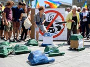 Auf kleinen Papp-Panzern werden die Unterschriften der Initiative für ein Verbot von Kriegsgeschäften zur Bundekanzlei gebracht. (Bild: KEYSTONE/ANTHONY ANEX)