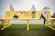Vertreter des OK des Kantonalen Turnfestes 2018 in Romanshorn posieren auf der eigens für den Anlass gezimmerten Parkbank im Romanshorner Hafen. (Bild: Reto Martin)
