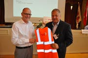 Erwin Rutishauser (links) übergibt seinem Nachfolger Carlo Parolari eine Warnweste als Geschenk. (Bild: Sebastian Keller)
