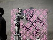 Auf Twitter wird gejubelt: Banksy ist zum ersten Mal in Paris! Bisher sind in der französischen Hauptstadt sechs mutmassliche Motive des Inkognito-Künstlers aufgetaucht. Hier ein Flüchtlingsmädchen, das ein Hakenkreuz mit einem rosa Blumenmuster übersprayt. (Twitter) (Bild: Twitter)