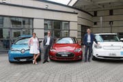 Regula Hürlimann, Georges Helfenstein und Peter Hausherr posieren mit den Elektroautos. (Bild: Gemeinde Cham (25. Juni 2018))