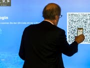 Der Zuger Stadtpräsident Dolfi Müller (SP) registriert sich auf der App, um mit seinem Handy an der ersten blockchain-basierten Abstimmung teilnehmen zu können. Die Stadt Zug will mit diesem E-Voting-System eine Vorreiterrolle in der Schweiz übernehmen. (Bild: KEYSTONE/ALEXANDRA WEY)