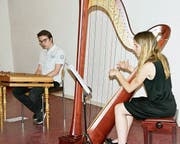Während die junge Harfenistin Salome Flammer spielt, hört Christopher Thwaites, Hackbrettspieler, in der Buchser Kulturstüdtlimühle aufmerksam zu. (Bild: Heidy Beyeler)