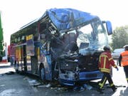 Der verunglückte Reisebus auf der deutschen Autobahn 5. Beim Zusammenstoss des Busses mit einem Abfalltransporter kam eine 30-jährige Reiseleiterin ums Leben. Dutzende weitere Menschen wurden verletzt. (Bild: Keystone/DPA/ULI DECK)