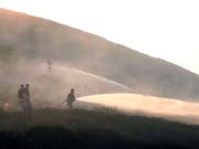 Feuerwehrleute kämpfen gegen den Brand im Saddleworth-Moor. Das Feuer war am Sonntag ausgebrochen. (Bild: Keystone/AP PA/PETER BYRNE)