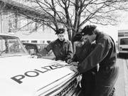 Polizisten besprechen sich zur Suche nach der verschwundenen Edith Trittenbass vor deren Schulhaus in Wolfikon. (Bild: KEYSTONE/STR)