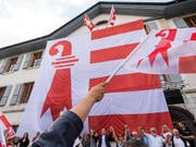 Am 18. Juni gedachten separatistische Anhänger dem Abstimmungssieg vor einem Jahr. Am Rathaus von Moutier wurde eine riesige Jura-Fahne aufgezogen. (Bild: KEYSTONE/JEAN-CHRISTOPHE BOTT)