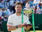 Mischa Zverev präsentiert seine erste Siegertrophäe auf der ATP-Tour (Bild: KEYSTONE/AP PA/GARETH FULLER)
