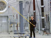 Unter der Regenanlage im Hochspannungslabor der ETH Zürich können die Forschenden das Verhalten von hybriden Stromleitungen genau untersuchen. (Bild: ETH High Voltage Lab/Jurij Pachin)