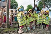 Die Kinder und damit die künftigen Nutzer der Neubauten standen am gestrigen Baustart im Fokus. Im Hintergrund sind Architekt Peter Moor (links) und Gemeinderat Markus Scheidegger zu sehen. (Bild: PD/Hans Galliker)