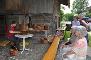 Interessiert verfolgen die Besucherinnen und Besucher des Bohlenständerhauses, wie Peter Schär einen Korb fertigt. (Bild: Ramona Riedener)