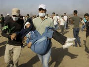 Palästinensische Sanitäter und Demonstranten evakuieren eine verletzte Jugendliche. (Bild: KEYSTONE/AP/ADEL HANA)
