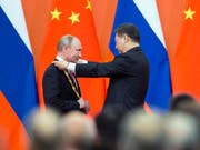 Chinas Präsident Xi Jinping ehrt seinen Gast aus Russland, Wladimir Putin, mit der erstmals verliehenen goldenen Ehrenmedaille. (Bild: KEYSTONE/AP POOL/ALEXANDER ZEMLIANICHENKO)