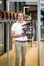 Unternehmer Dario My steht im Raum, wo die Kuckucksuhren zwei bis drei Wochen lang Probe laufen, ehe sie versendet werden. Er präsentiert ein noch grösseres Modell. (Bild: Reto Martin)