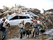 Rettungskräfte im Südwesten Japans bergen nach heftigen Regenfällen und Schlammlawinen immer mehr Leichen. (Bild: KEYSTONE/AP Kyodo News)