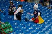 Japanische Fans räumen im Stadion auf. (Bild: AP Photo/Pavel Golovkin)