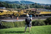 Bauen vor Publikum: Arbeiter heben die Gleise der Bahnstrecke in Winkeln mit einem grossen Bauzug an. (Bild: Benjamin Manser)