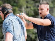Sieger Lario Kramer (rechts) befreit den unterlegenen Schwingerkönig Matthias Glarner vom Sägemehl (Bild: KEYSTONE/PETER SCHNEIDER)