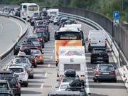 In der Sonne, aber noch nicht im Süden: Stau am Wochenende auf der Autobahn A2 bei Erstfeld UR. (Bild: KEYSTONE/URS FLUEELER)