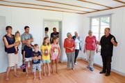 Kirchenpräsident Martin Dönni (rechts) zeigt einer Besuchergruppe das frisch renovierte Pfarrhaus. (Bild: Christoph Heer)