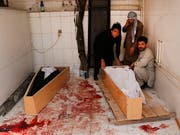Verwandte betten ein Opfer eines Selbstmordanschlags in Kabul in einen Sarg - Noch nie wurden in Afghanistan so viele Zivilisten bei Gefechten oder Anschlägen getötet wie im ersten Halbjahr 2018. (Bild: KEYSTONE/EPA/HEDAYATULLAH AMID)