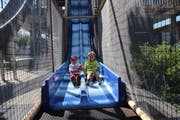 Auf drei verschiedenen Wegen geht es vom Kletterturm hinunter. Samuel und Michael haben sich für die Doppelrutschbahn entschieden. (Bild: Annina Quast)