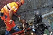 Baustellenchef Marcel Schmidiger und Taucher Reto Rohrer von der Kibag Bauleistungen AG setzen Schalelemente für Unterwasser-Betonarbeiten an der seitlichen Ufermauer. (Bild: Matthias Piazza (Buochs, 12. Juli 2018))