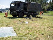 Polizisten untersuchen das in Linden BE verunfallte Transportfahrzeug der Armee, nachdem dieses wieder aufgerichtet worden ist. (Bild: Keystone/Peter Schneider)