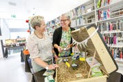 Die Pro-Manu-Vorstandsmitglieder Barbara Rossbacher und Yvonne Joos in der Bibliothek der PHTG. Die dort ausgestellten Koffer haben Lehrerinnen für textiles und technisches Gestalten für die Jubiläumsversammlung des Vereins gemacht. (Bild: Donato Caspari)